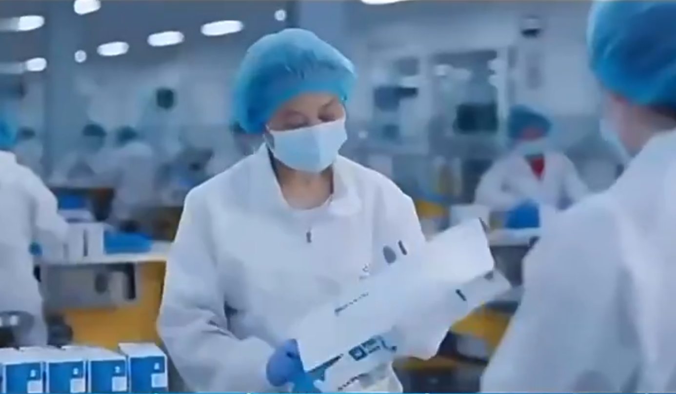 Factory staff handling glove product checks inside a clean production room